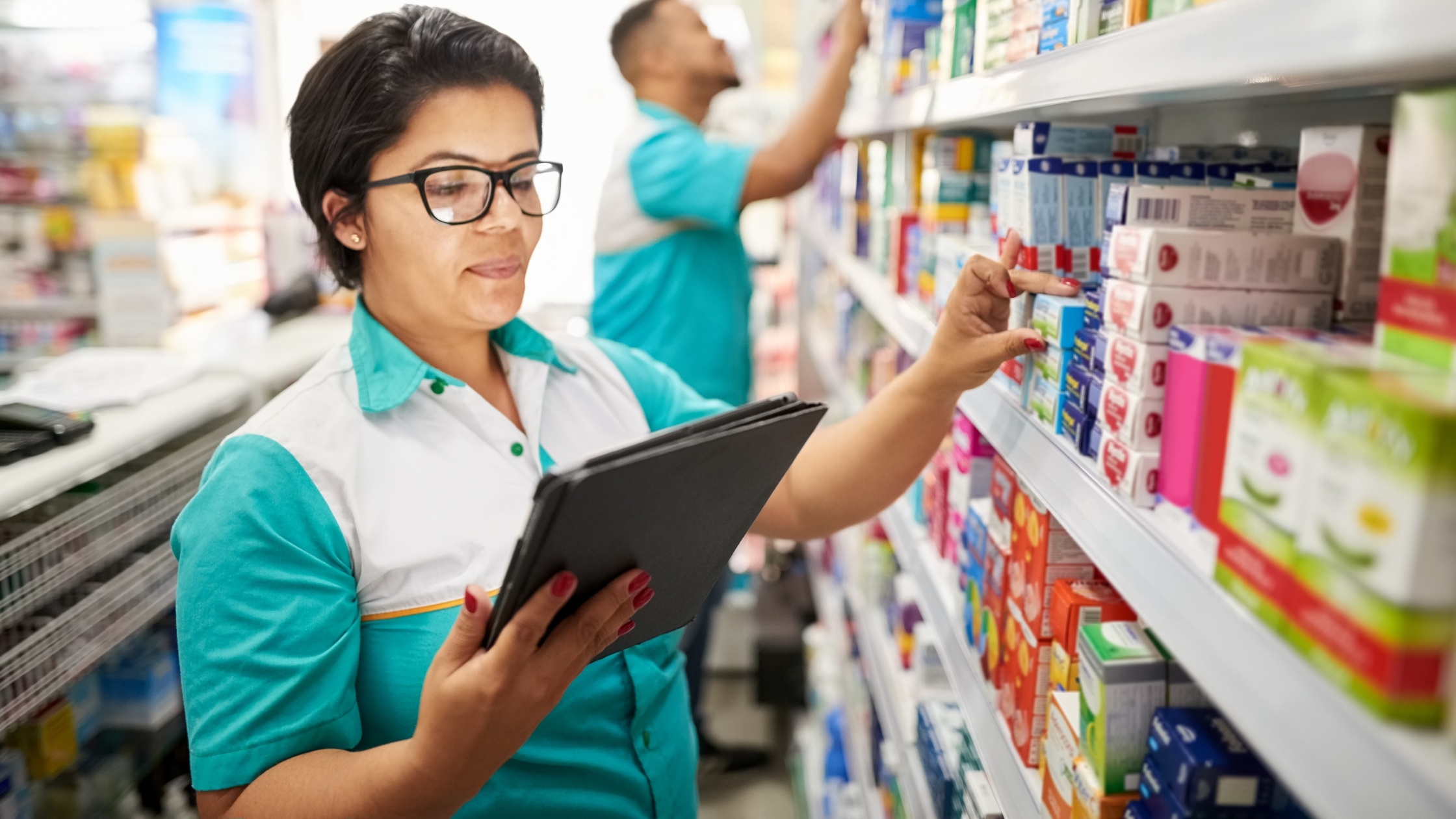 Woman with iPad counting inventory at a pharmacy